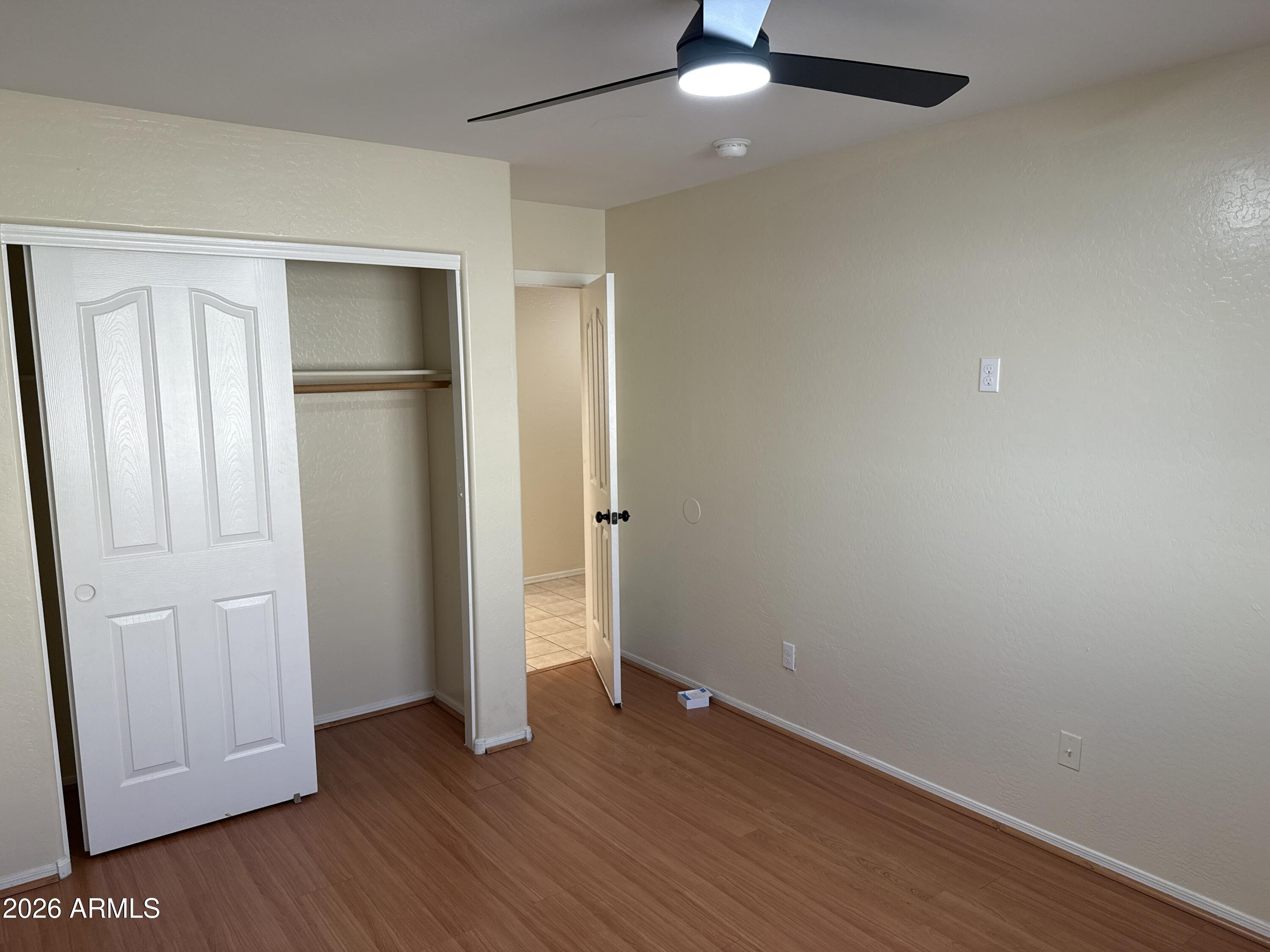 9630 West Reno View Drive Peoria, AZ 85345 - Photo 12 of 21 an empty room with wooden floor cabinet and ceiling fan