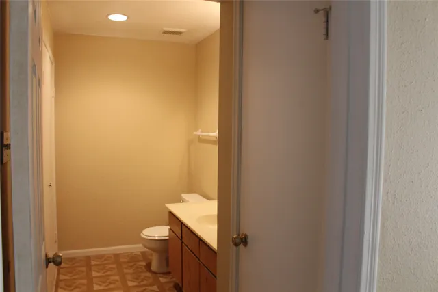 a bathroom with a granite countertop toilet and a sink