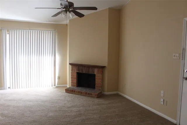 an empty room with windows and fireplace