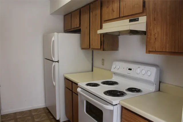 a kitchen with a refrigerator and a stove top oven