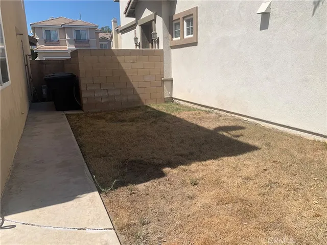 a view of backyard with table and chairs under an umbrella