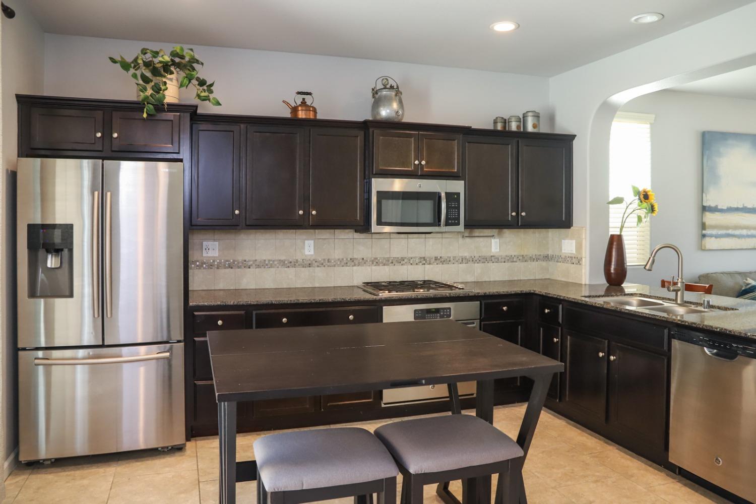 3511 Generosity Way Clovis, CA 93619 - Photo 7 of 26 a kitchen with a refrigerator a stove a sink and cabinets