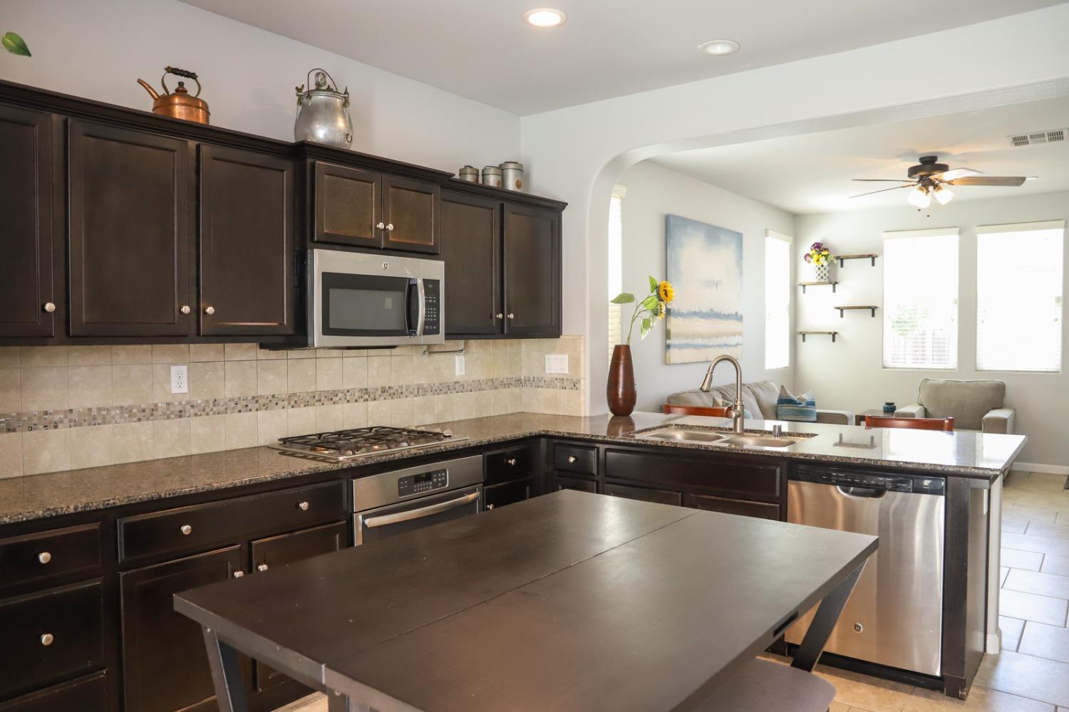 3511 Generosity Way Clovis, CA 93619 - Photo 8 of 26 a kitchen with a stove a sink and a microwave