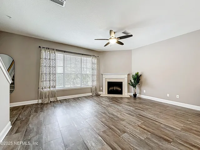 a kitchen with stainless steel appliances a refrigerator a sink a stove and white cabinets with wooden floor