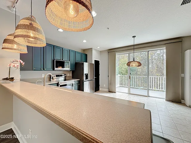 a large kitchen with a sink and dishwasher a stove top oven with a bookshelf