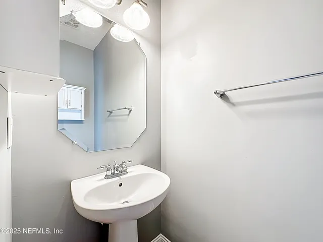 a bathroom with a granite countertop toilet a sink and a mirror