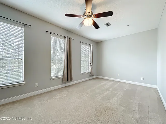 a spacious bathroom with a granite countertop sink mirror and a bathtub