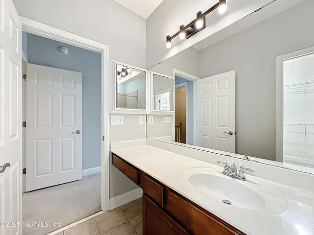 an empty room with chandelier fan and windows