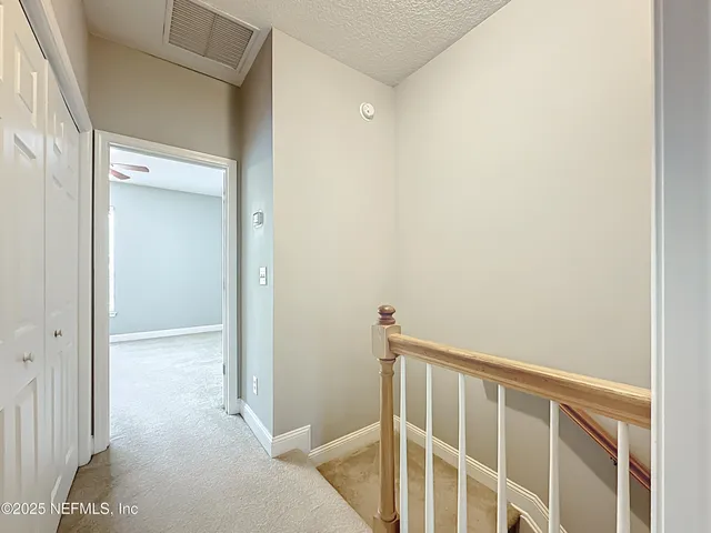 an empty room with closet and a ceiling fan
