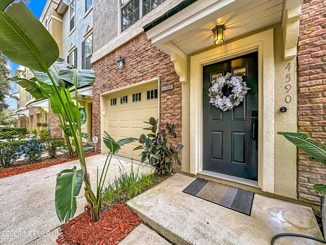 a view of staircase with lots of frames on wall and a window