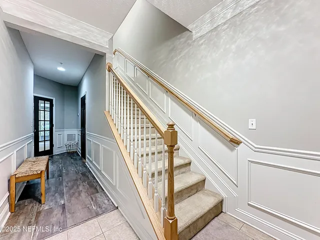 a view of an empty room with wooden floor fireplace and a window