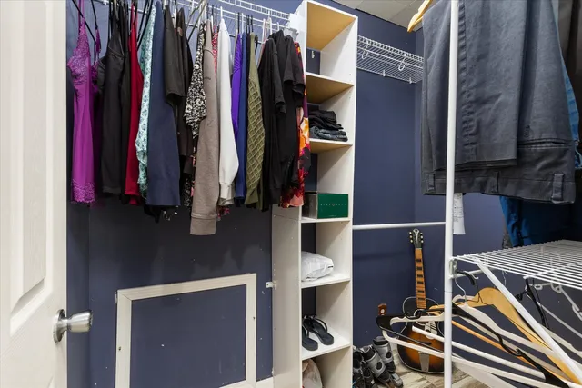 a spacious bedroom with a bed and a dresser in it