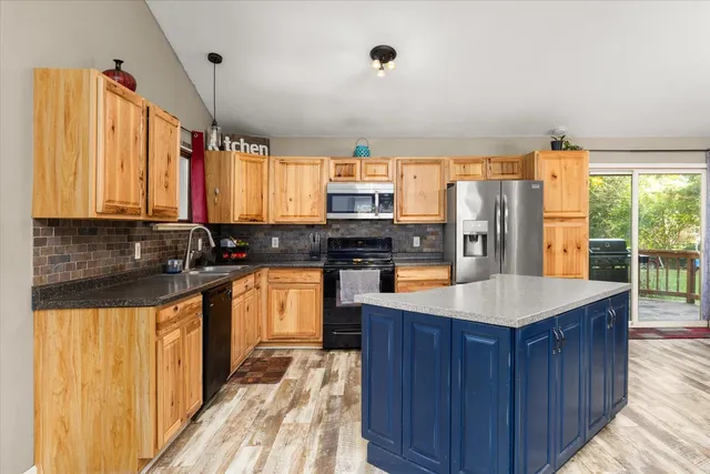 a kitchen with granite countertop a refrigerator and a sink
