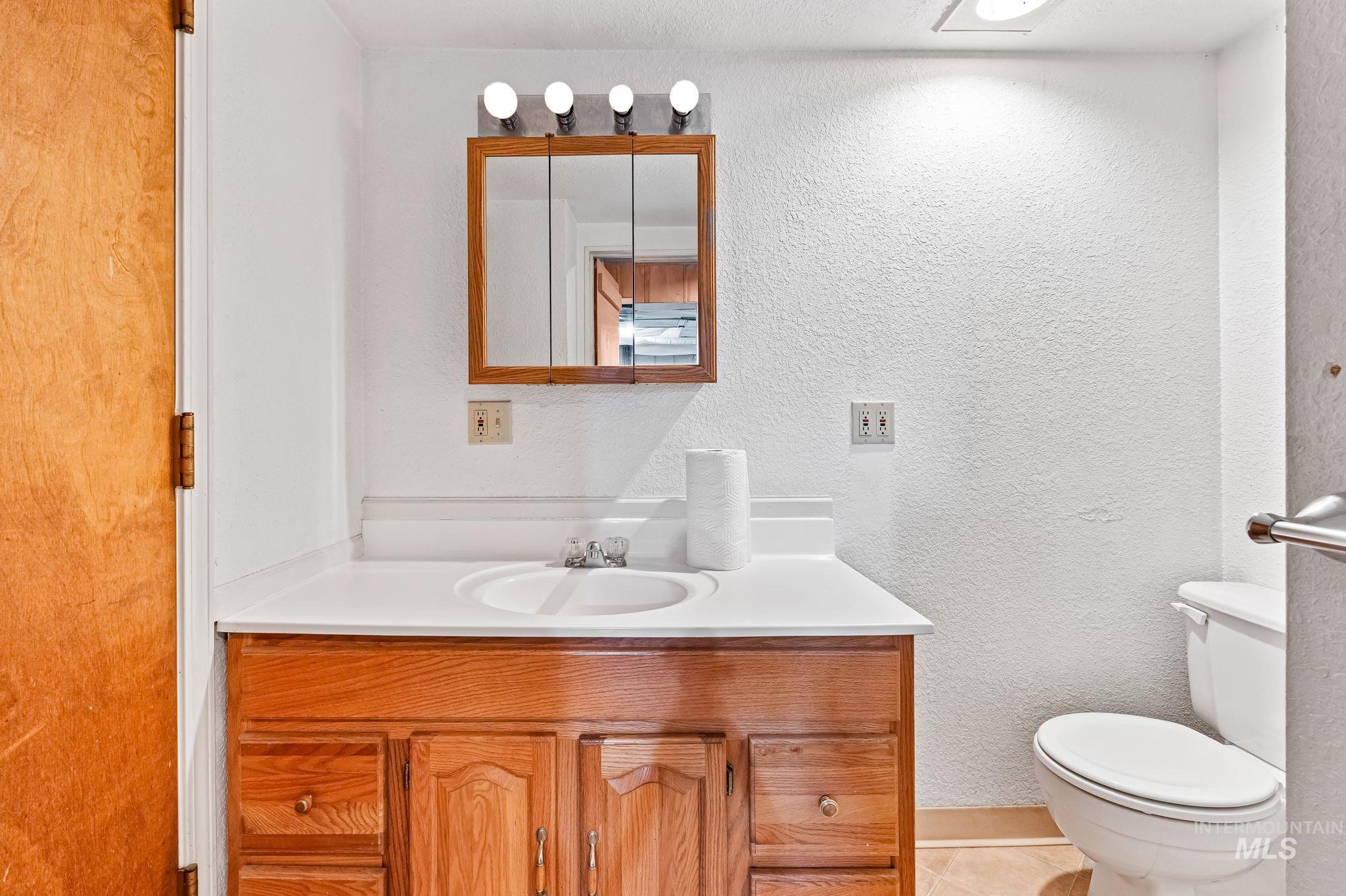 404 North Allumbaugh Street Boise, ID 83704 - Photo 13 of 31 Bathroom with vanity, a textured wall, and tile patterned floors