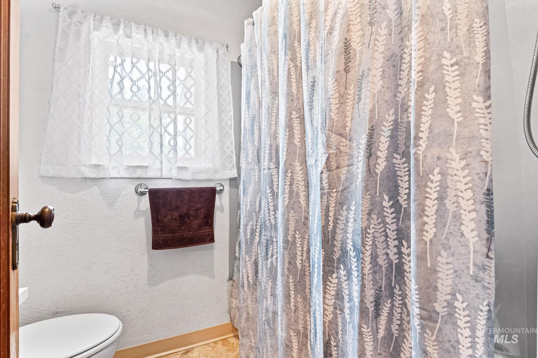 404 North Allumbaugh Street Boise, ID 83704 - Photo 19 of 31 Bathroom featuring toilet and curtained shower
