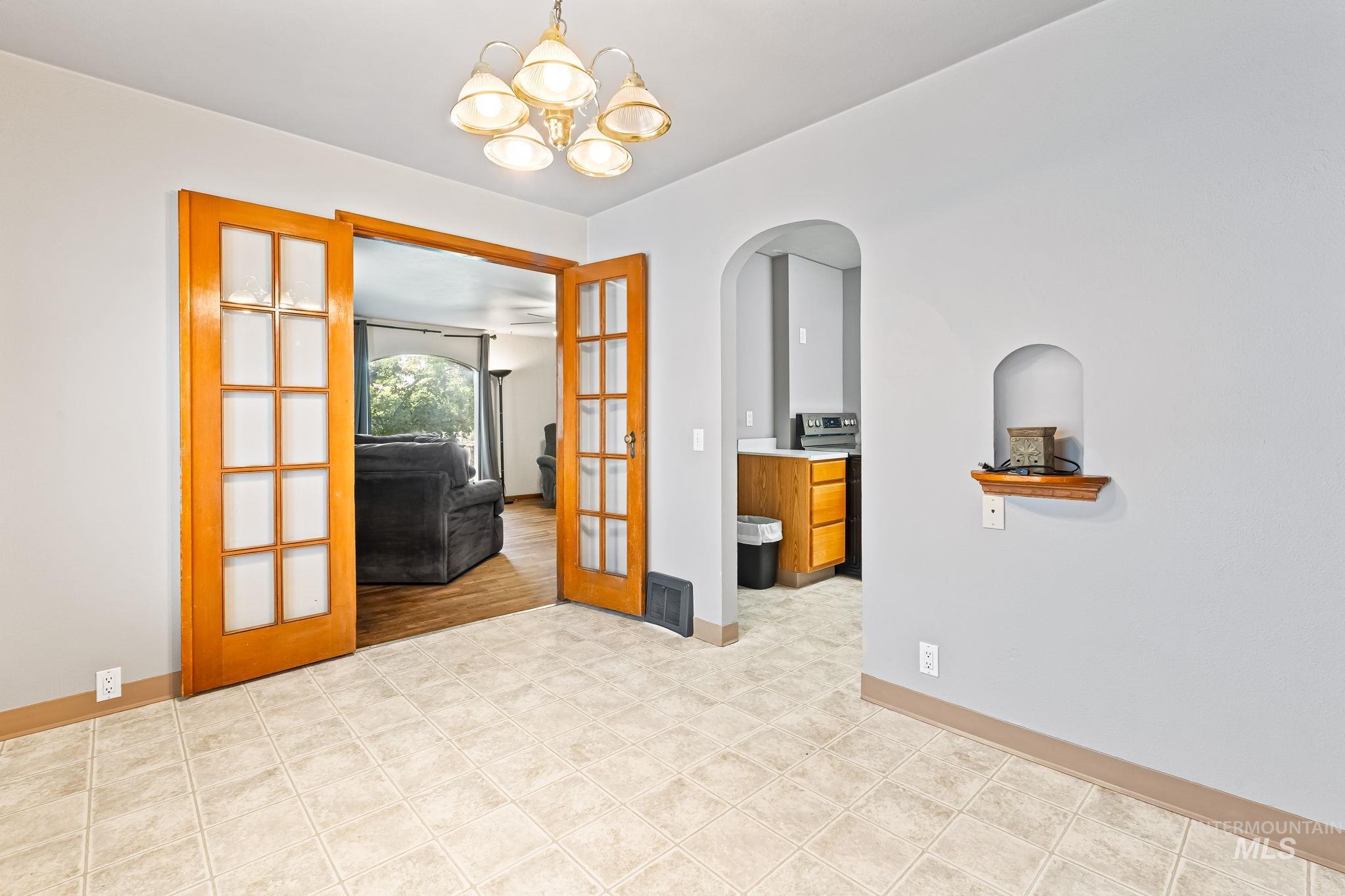 404 North Allumbaugh Street Boise, ID 83704 - Photo 24 of 31 Unfurnished room featuring french doors, a chandelier, and arched walkways