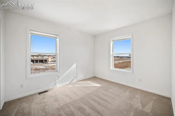 an empty room with closet and a chandelier fan