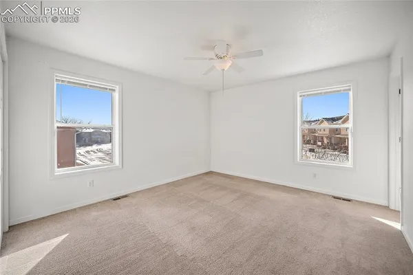 an empty room with chandelier fan
