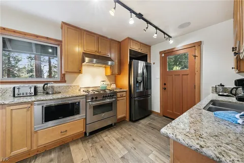 a kitchen with stainless steel appliances granite countertop a stove and a refrigerator