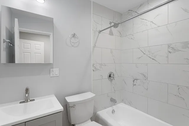 a bathroom with a toilet a sink a mirror and vanity