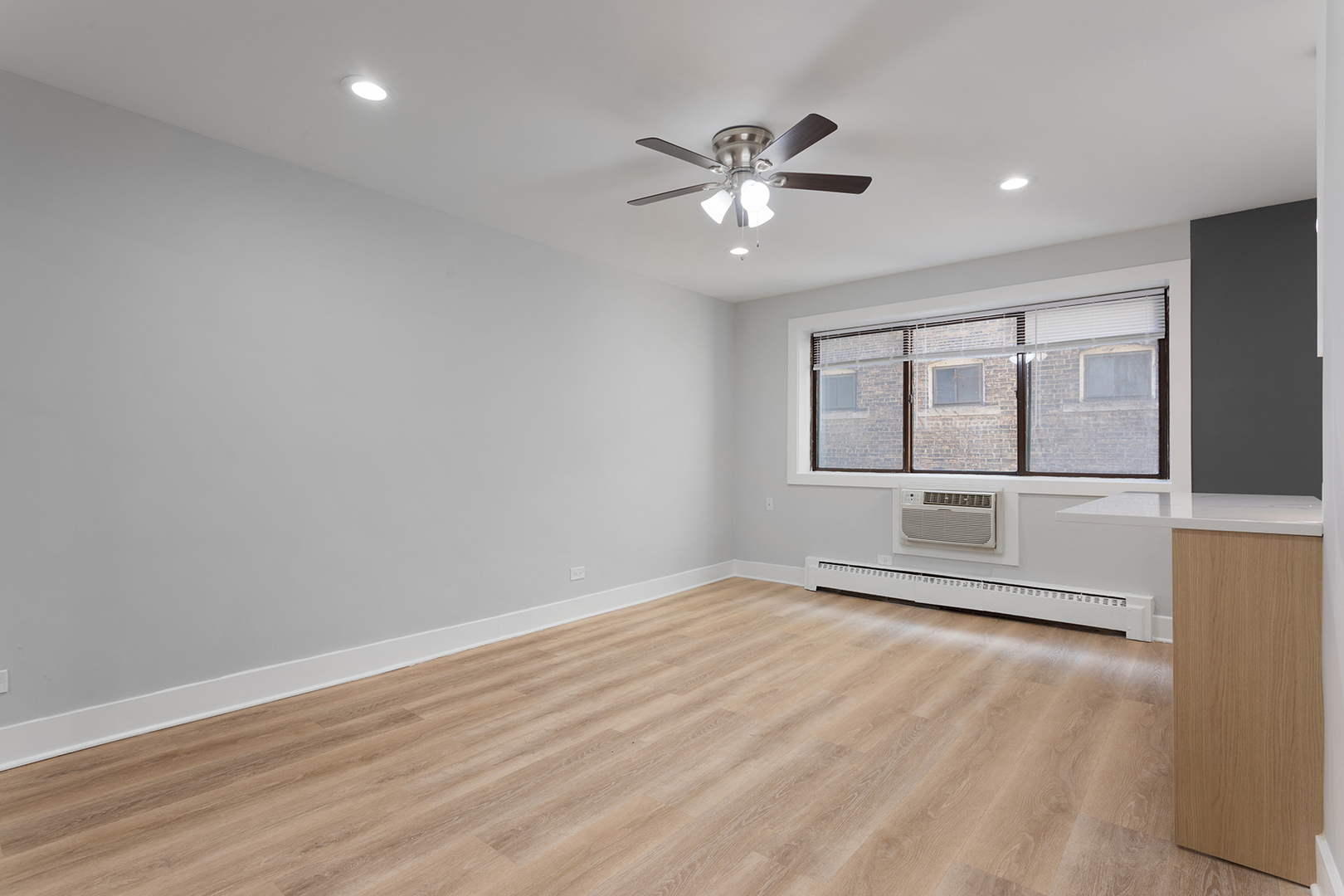 5534 North Kenmore Avenue, Unit 206 Chicago, IL 60640 - Photo 2 of 13 an empty room with wooden floor and windows
