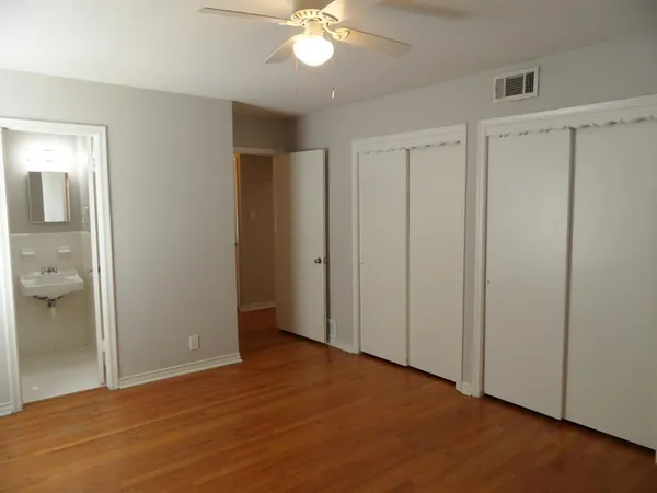 an empty room with wooden floor and closet area