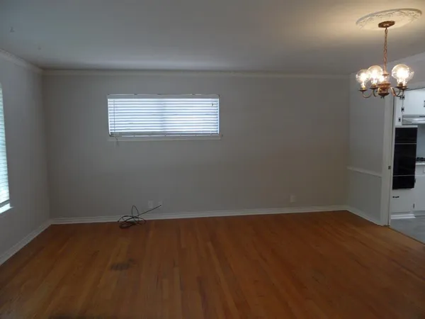 a view of a room with wooden floor and chandelier