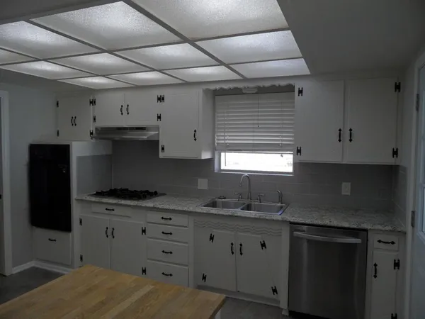 a kitchen with cabinets appliances and a window