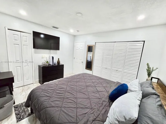 a bedroom with a large bed and a flat screen tv