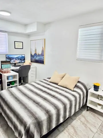a bedroom with a bed and a workspace