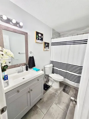 a bathroom with a sink a toilet and a mirror