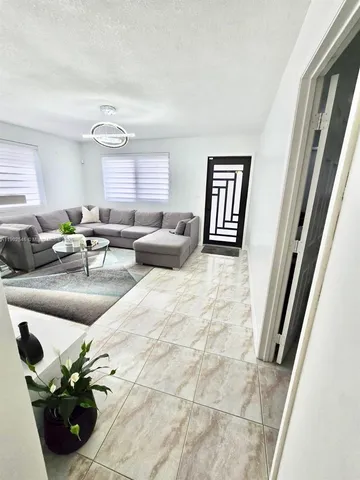 a living room with furniture and a potted plant