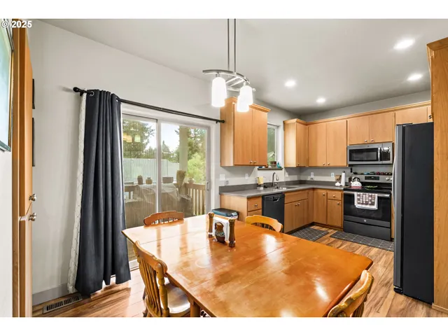 a kitchen with stainless steel appliances kitchen island granite countertop a refrigerator a stove top oven and a view of kitchen island