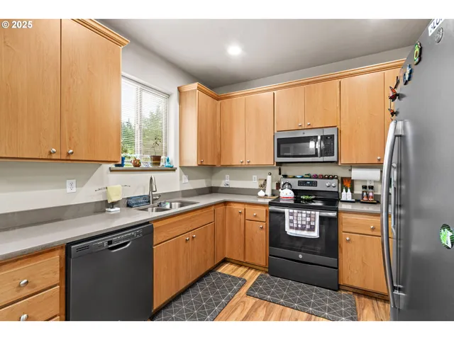 a kitchen with stainless steel appliances granite countertop a sink a stove and cabinets