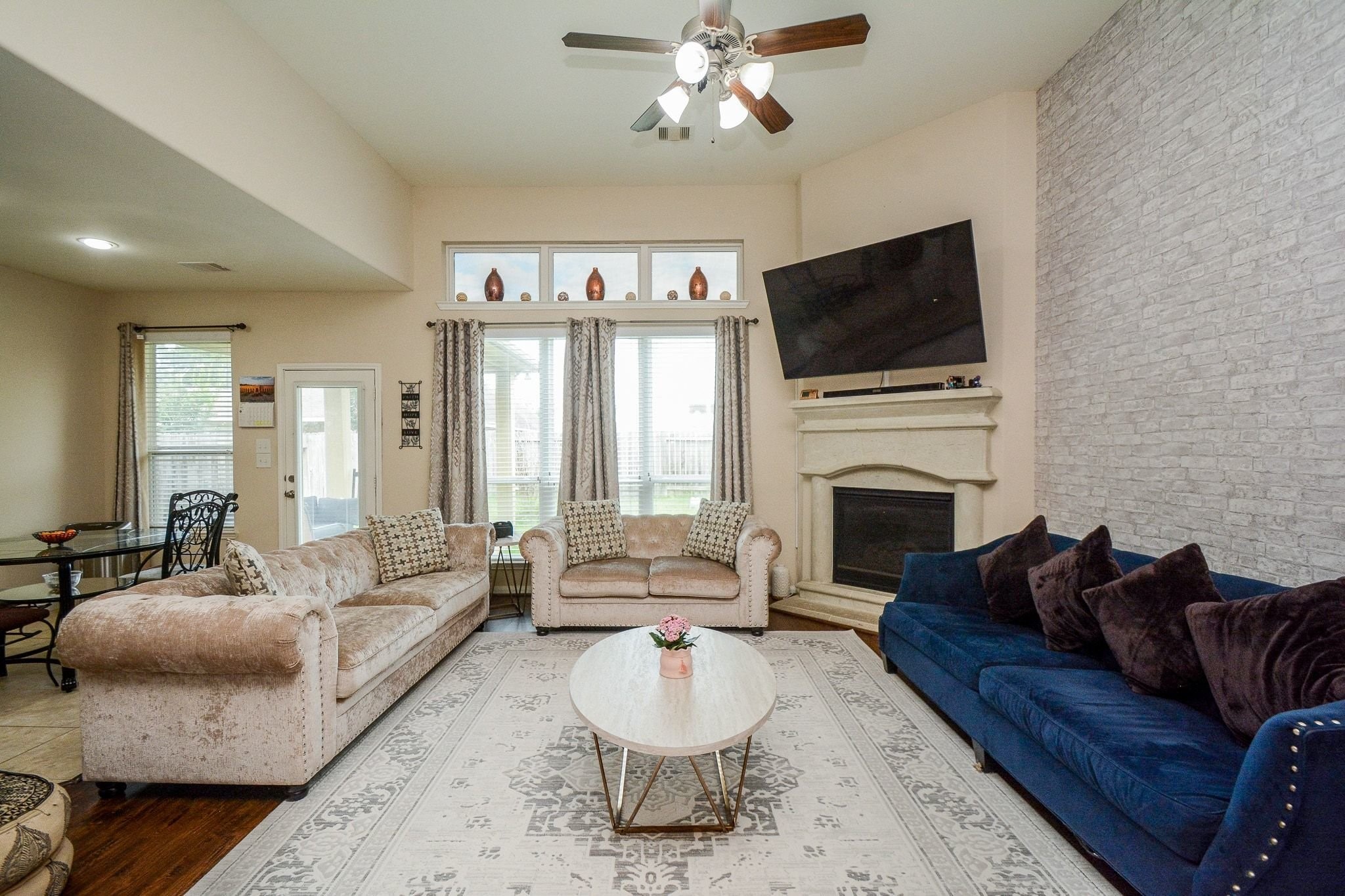 7046 Sliding Rock Circle Spring, TX 77379 - Photo 9 of 41 Spacious and inviting living room featuring high ceilings, a cozy fireplace, and abundant natural light. Ideal for relaxation and entertaining.