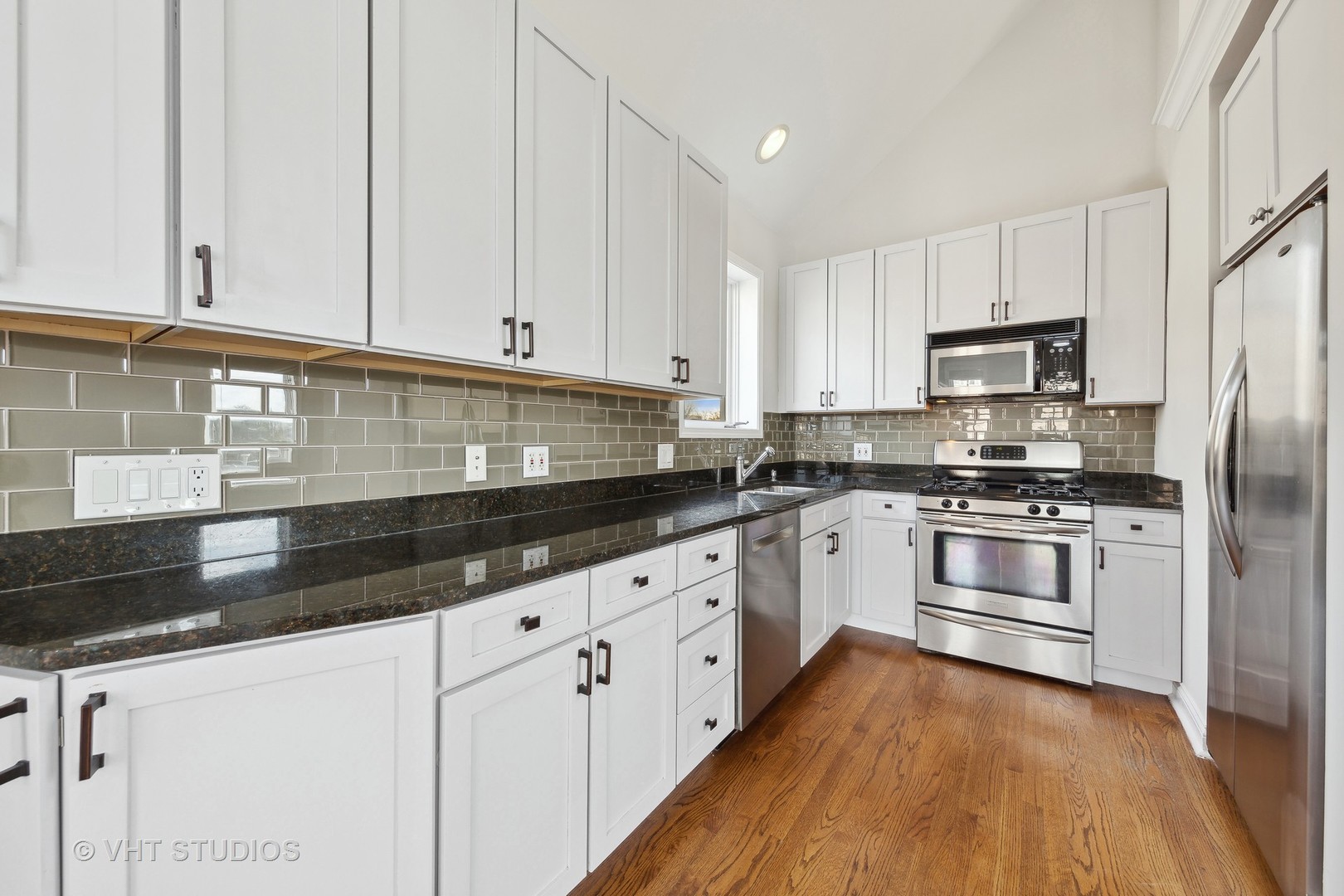 2031 West Augusta Boulevard, Unit 3 Chicago, IL 60622 - Photo 8 of 24 a kitchen with granite countertop white cabinets and stainless steel appliances