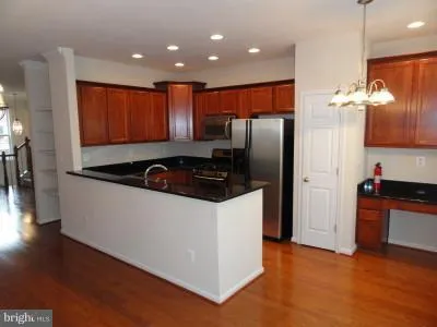 a kitchen with stainless steel appliances granite countertop a refrigerator a sink and a stove