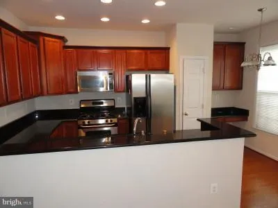 a kitchen with stainless steel appliances a sink a stove a microwave and a refrigerator