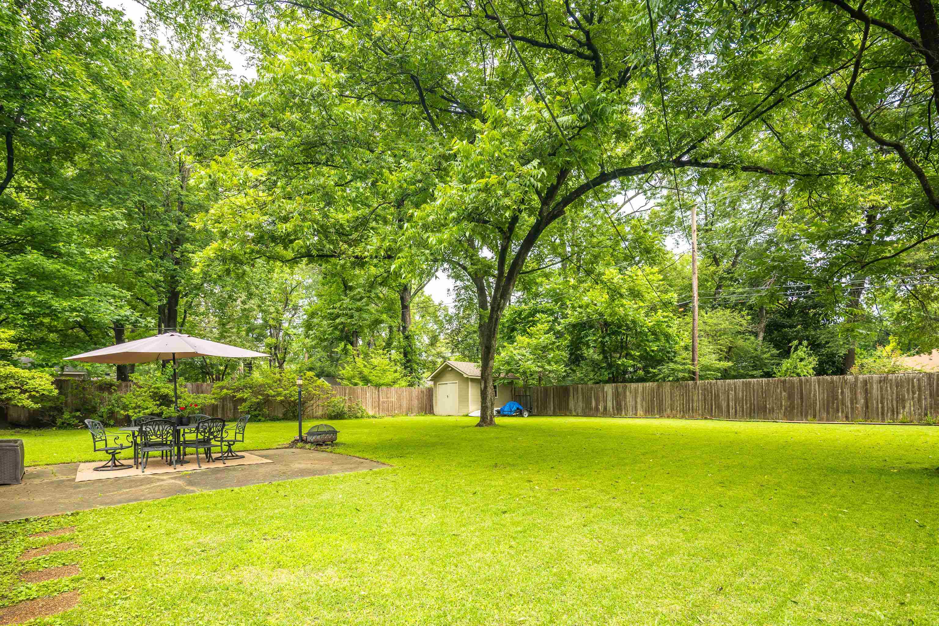 4152 Barfield Road Memphis, TN 38117 - Photo 36 of 37 Fenced backyard featuring a storage shed, a patio area, and view of wooded area