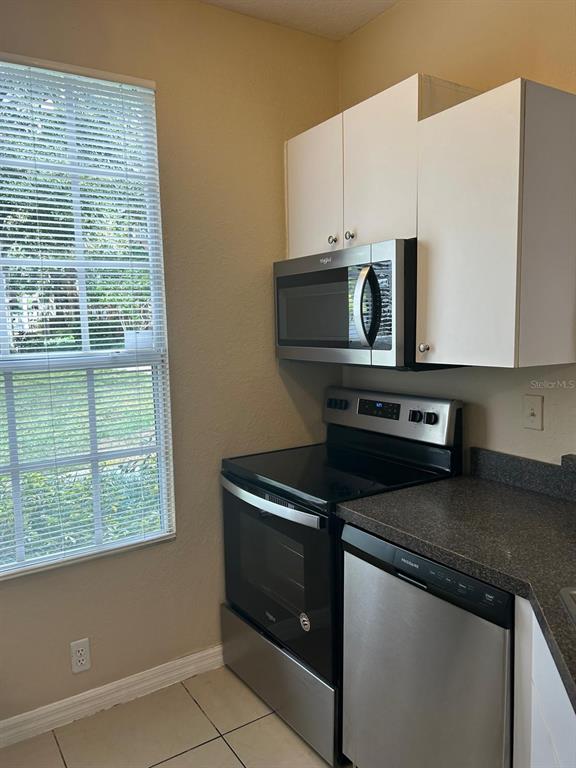 6408 Raleigh Street, Unit 2403 Orlando, FL 32835 - Photo 6 of 18 a kitchen with a stove microwave and sink