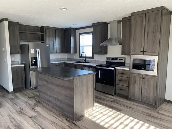 a kitchen with kitchen island granite countertop a sink stove and refrigerator