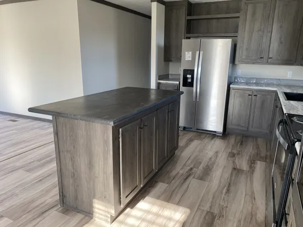 a kitchen with a refrigerator and wooden floor