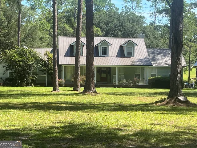 a view of a house with a yard and sitting area