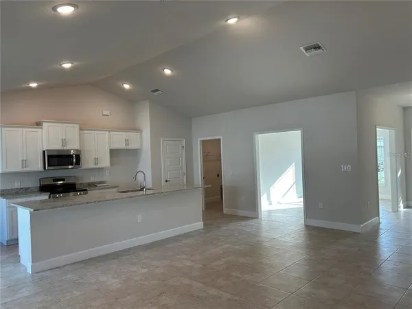 a large kitchen with stainless steel appliances granite countertop a stove a sink and a refrigerator