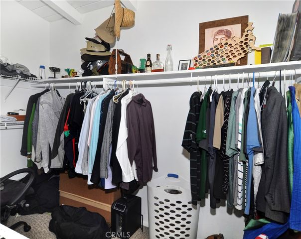 a view of walk in closet with clothes and shoes