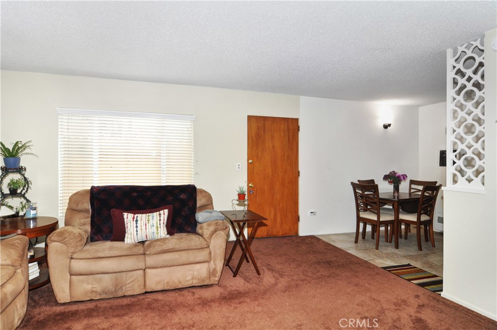 217 10th Street, Unit 4 Seal Beach, CA 90740 - Photo 17 of 45 a living room with furniture a dining table and a potted plant