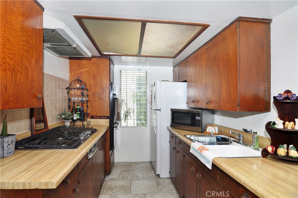 217 10th Street, Unit 4 Seal Beach, CA 90740 - Photo 20 of 45 a kitchen with a stove and a refrigerator