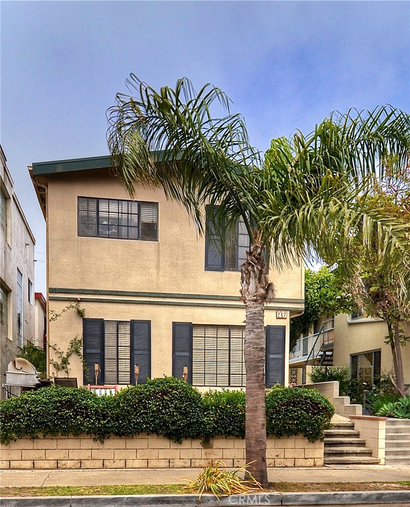 217 10th Street, Unit 4 Seal Beach, CA 90740 - Photo 2 of 45 a front view of a house with a yard and garage