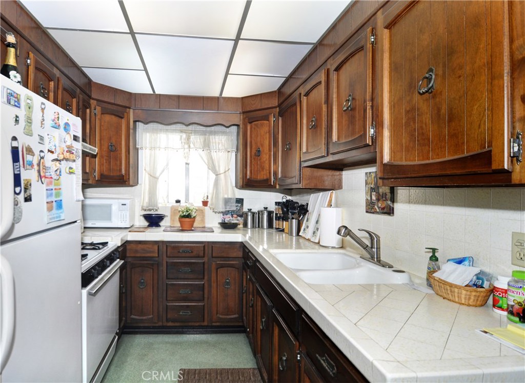 217 10th Street, Unit 4 Seal Beach, CA 90740 - Photo 29 of 45 a kitchen with stainless steel appliances granite countertop a sink stove and cabinets