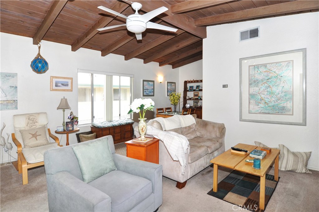 217 10th Street, Unit 4 Seal Beach, CA 90740 - Photo 32 of 45 a living room with furniture a chandelier and a window